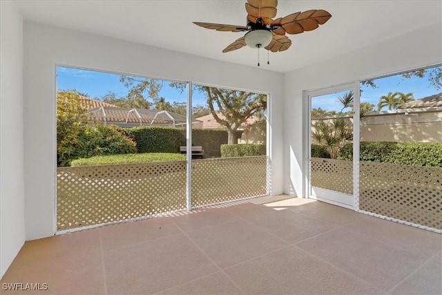 unfurnished sunroom featuring ceiling fan