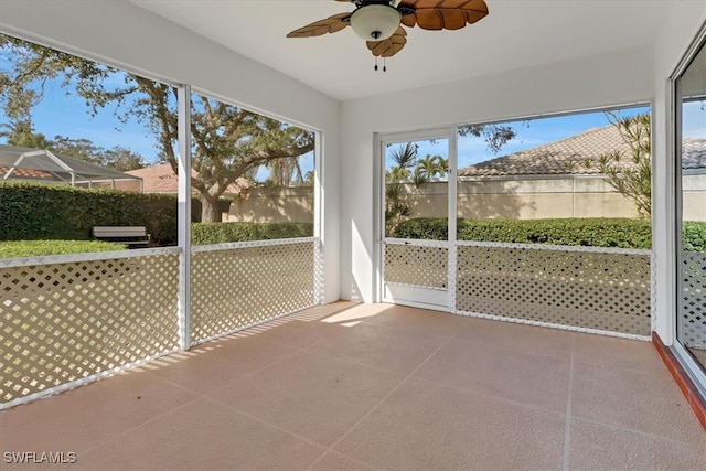 unfurnished sunroom featuring ceiling fan