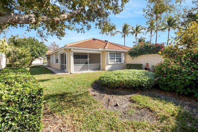 back of house featuring a yard and a sunroom