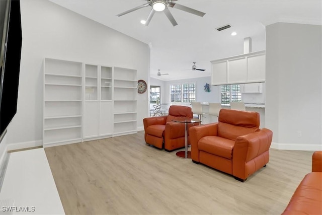 living room featuring visible vents, a ceiling fan, light wood-style floors, and baseboards