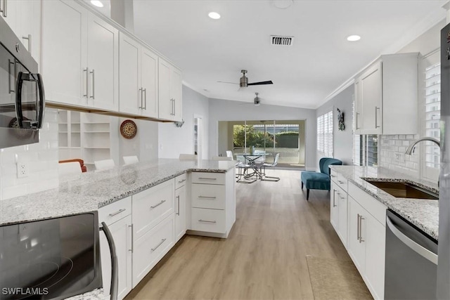 kitchen with ceiling fan, black microwave, a sink, light wood-type flooring, and stainless steel dishwasher