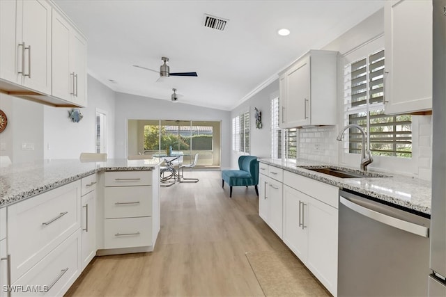 kitchen featuring stainless steel dishwasher, light stone countertops, white cabinetry, and sink