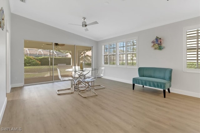 living area with ceiling fan, wood-type flooring, and lofted ceiling