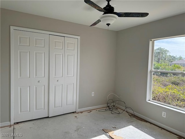 unfurnished bedroom with ceiling fan and a closet