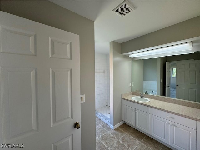 bathroom featuring tile patterned flooring, vanity, and walk in shower