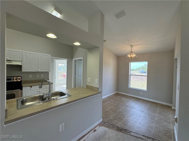 kitchen featuring white cabinetry, sink, a notable chandelier, stove, and decorative light fixtures