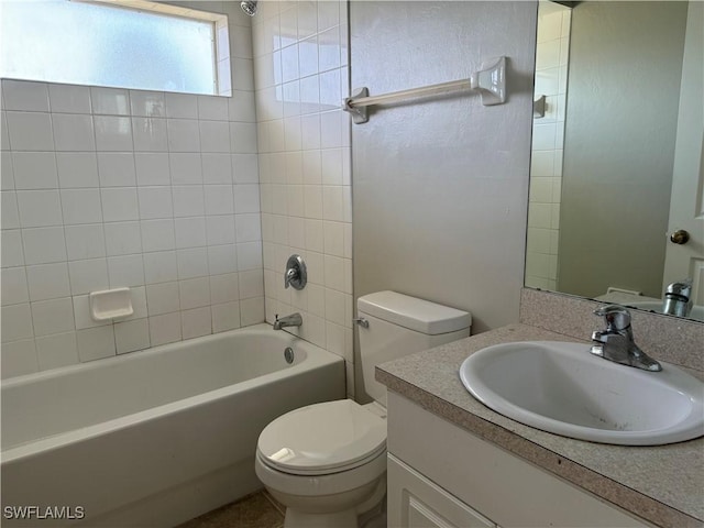 full bathroom with vanity, tiled shower / bath combo, and toilet