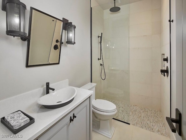 bathroom with tiled shower, toilet, tile patterned flooring, and vanity