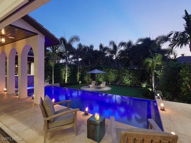 pool at dusk with a patio