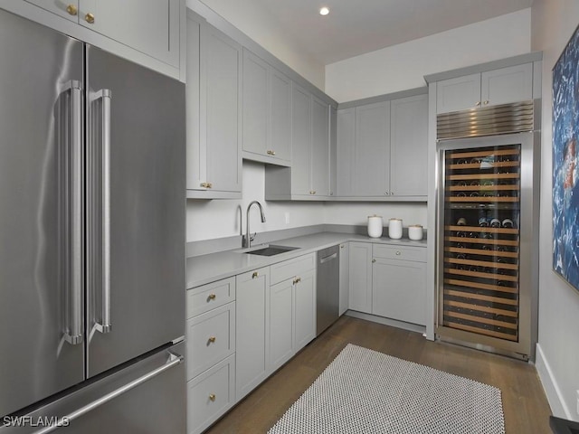 kitchen with sink, wine cooler, appliances with stainless steel finishes, and dark hardwood / wood-style flooring