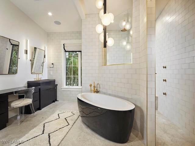 bathroom with shower with separate bathtub, vanity, and tile walls