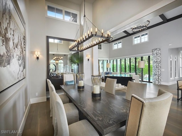 dining area with a chandelier, a towering ceiling, and dark hardwood / wood-style flooring