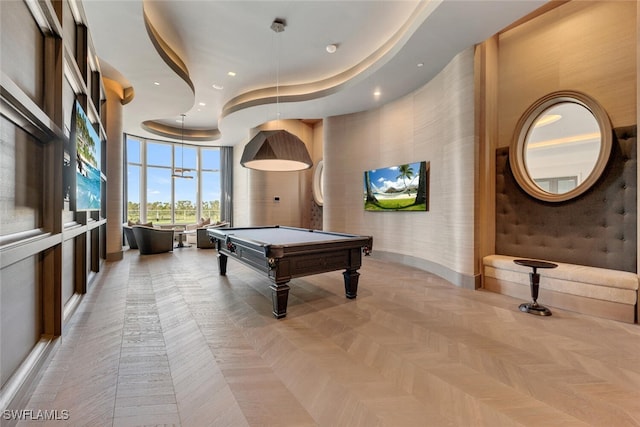 playroom featuring a towering ceiling, light parquet flooring, a raised ceiling, and billiards