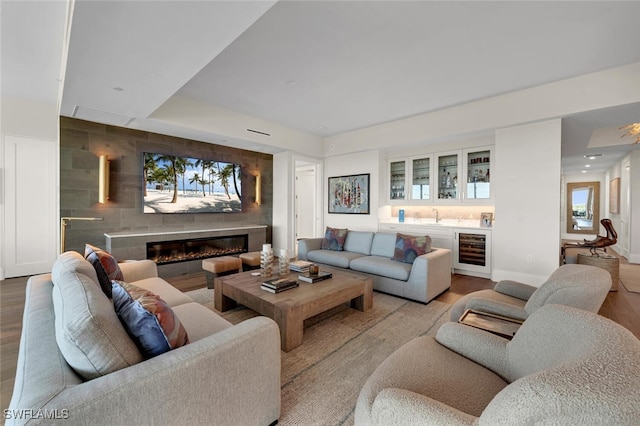 living room with wine cooler, light hardwood / wood-style floors, and indoor wet bar