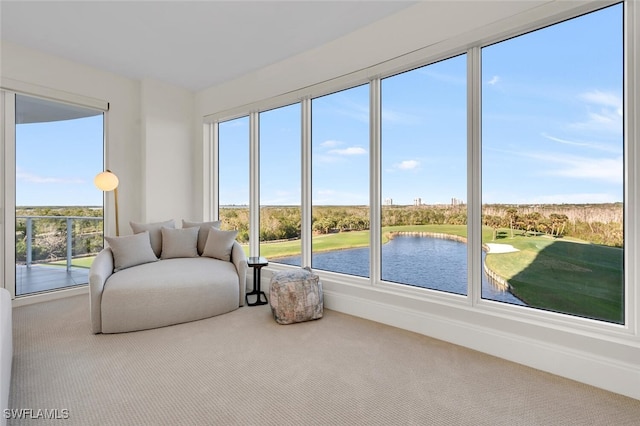 sunroom featuring a water view