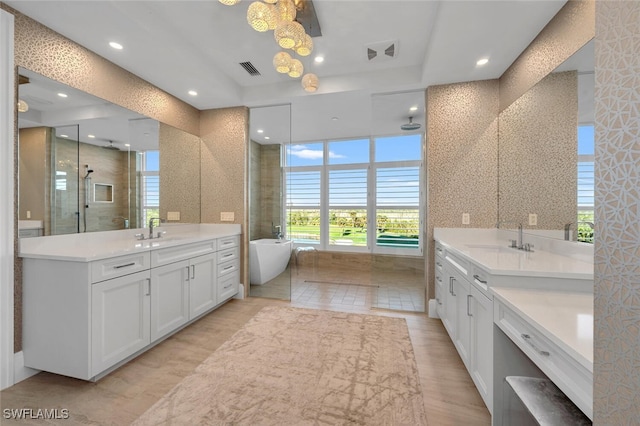 bathroom with hardwood / wood-style flooring, vanity, and shower with separate bathtub