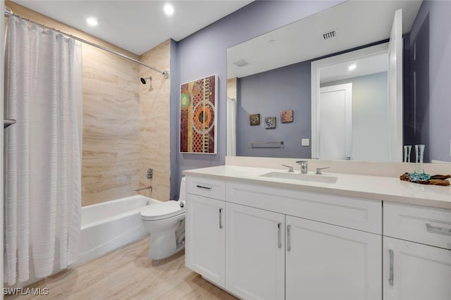 full bathroom with vanity, toilet, wood-type flooring, and shower / tub combo