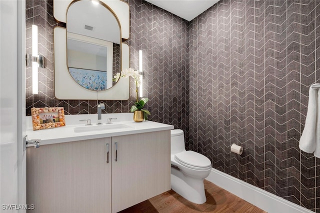 bathroom with vanity, toilet, and wood-type flooring