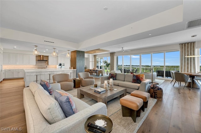 living room with ceiling fan and light hardwood / wood-style floors