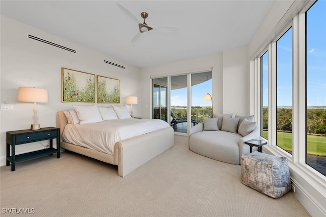 bedroom with access to exterior, multiple windows, light colored carpet, and ceiling fan