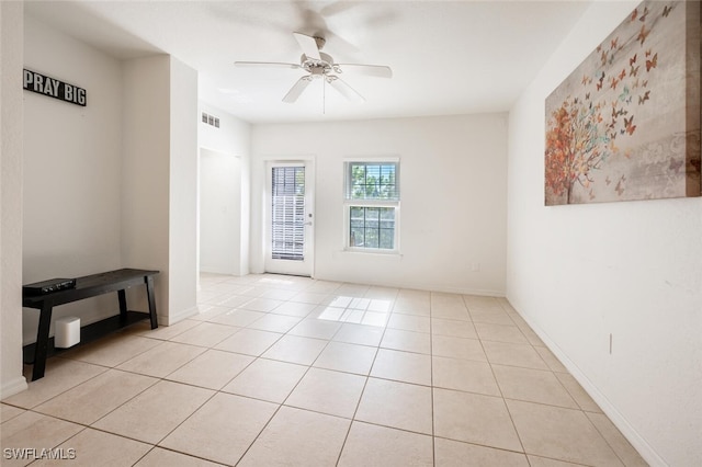 tiled spare room with ceiling fan