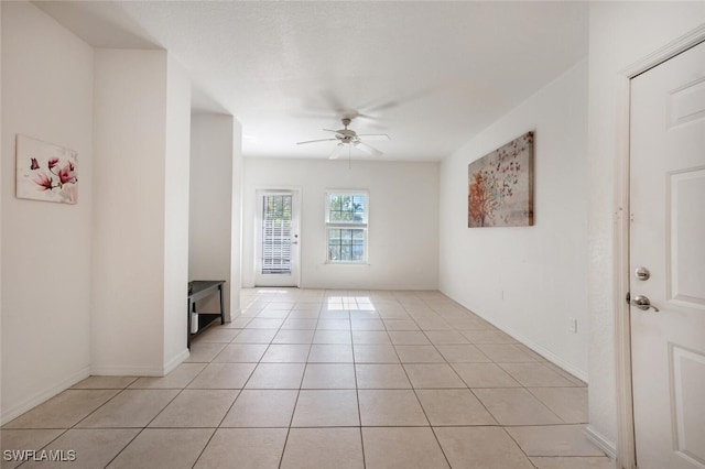 tiled spare room featuring ceiling fan