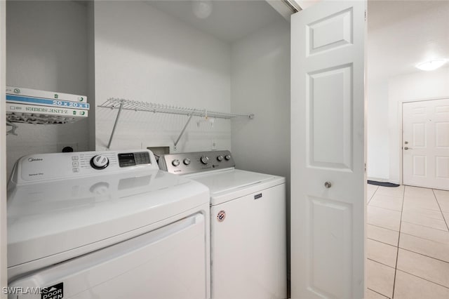 laundry area featuring independent washer and dryer and light tile patterned flooring