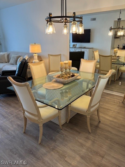 dining space with a chandelier and dark hardwood / wood-style floors