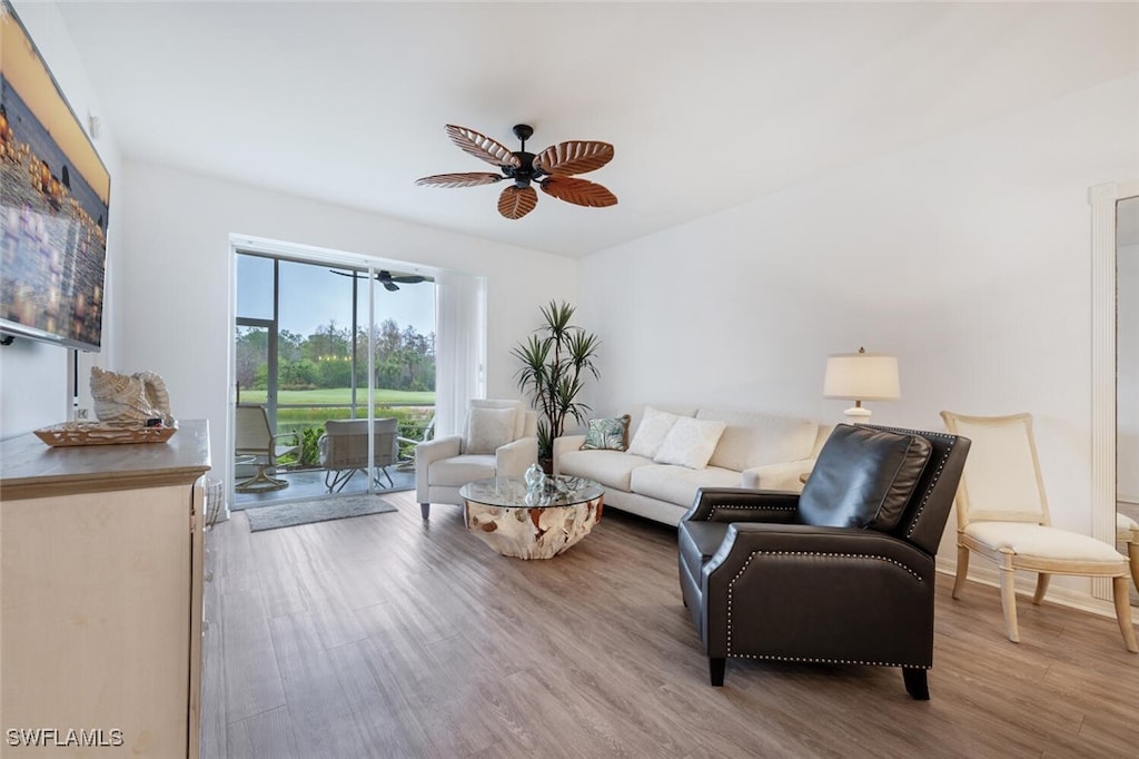 living room with ceiling fan and light hardwood / wood-style flooring