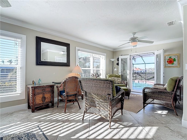 sitting room with a textured ceiling, ceiling fan, and crown molding