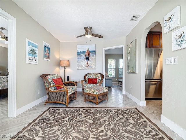 sitting room with ceiling fan and a textured ceiling