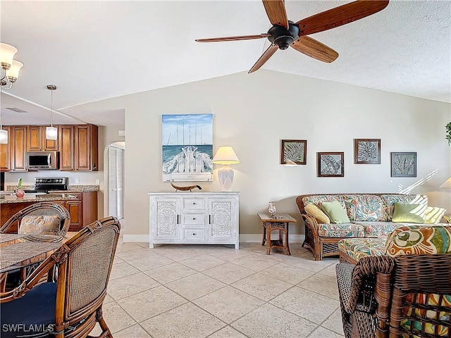 living room featuring ceiling fan, light tile patterned floors, and vaulted ceiling