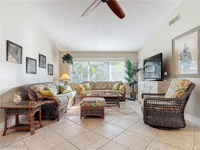 living room featuring ceiling fan and a textured ceiling