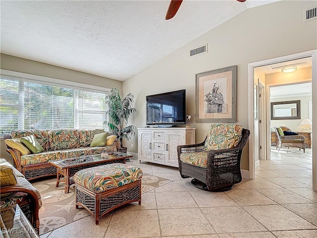 living room with a textured ceiling, ceiling fan, and lofted ceiling