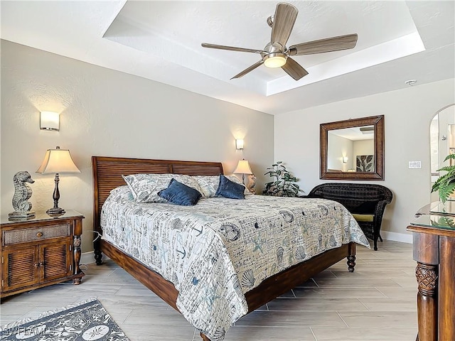 bedroom with a raised ceiling and ceiling fan