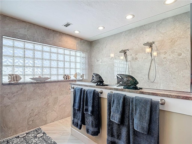 bathroom featuring a shower and tile walls