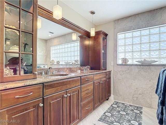 bathroom featuring vanity and tile walls