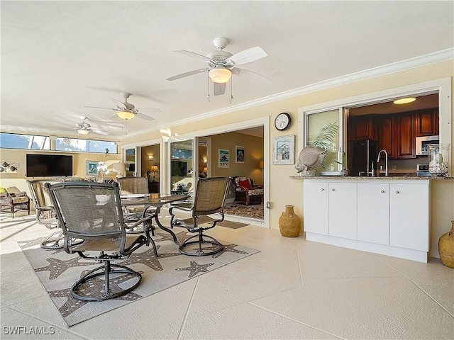 dining space with ceiling fan and ornamental molding