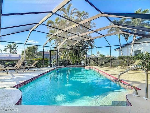 view of swimming pool featuring a patio area and a lanai