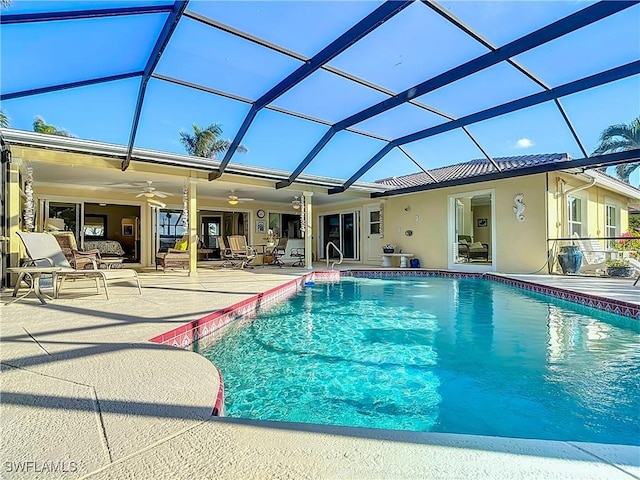 view of pool with a lanai, ceiling fan, and a patio