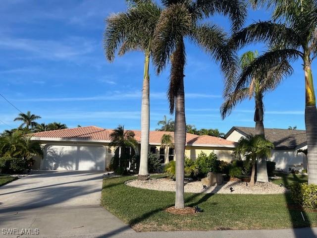 view of front of property with a garage and a front lawn