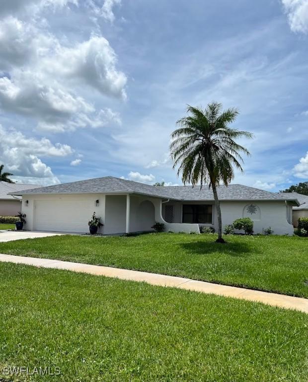 ranch-style home with a garage and a front yard