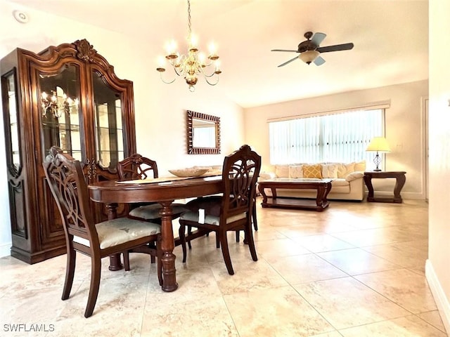 dining space with ceiling fan with notable chandelier, light tile patterned flooring, and lofted ceiling