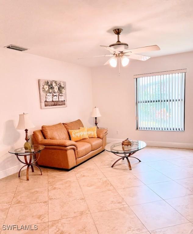 living room with ceiling fan and light tile patterned flooring