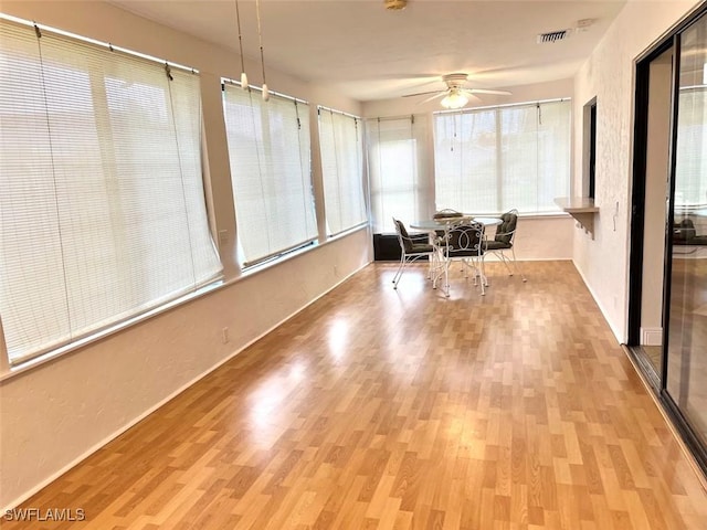 unfurnished sunroom featuring ceiling fan