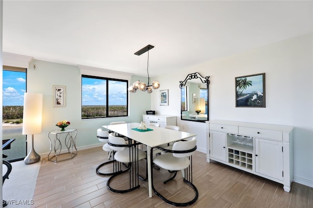 dining space featuring a notable chandelier and light wood-type flooring