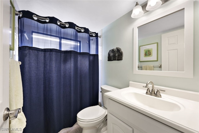 bathroom featuring curtained shower, vanity, and toilet