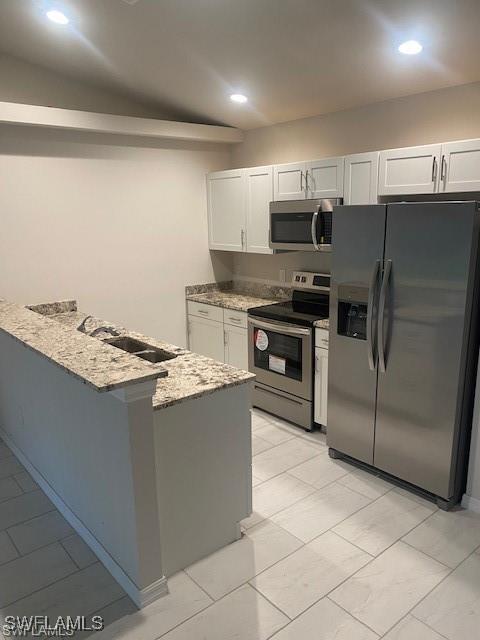 kitchen featuring light stone countertops, white cabinetry, sink, and appliances with stainless steel finishes