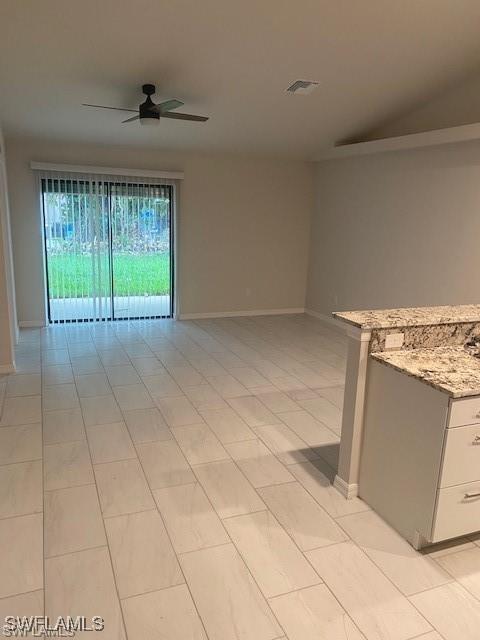 spare room with ceiling fan and light tile patterned flooring