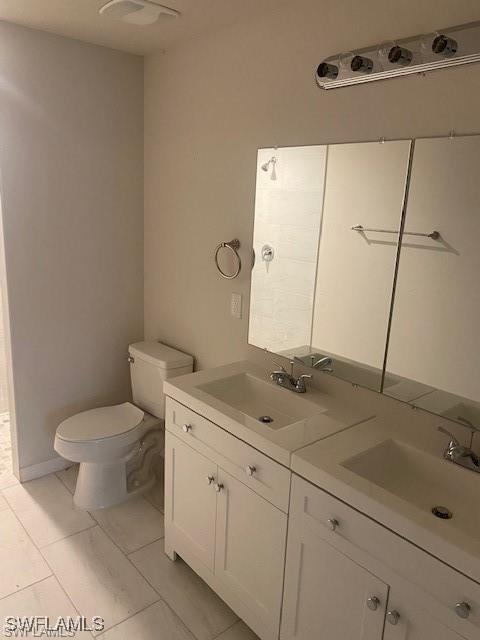 bathroom featuring tile patterned flooring, vanity, and toilet